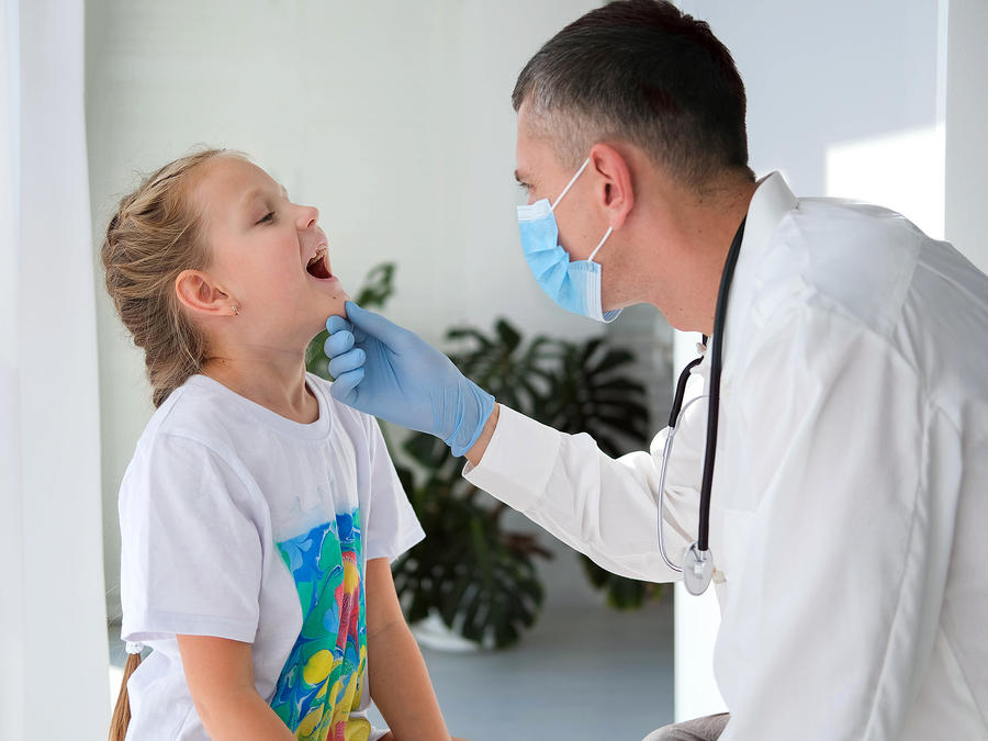 dentist looking in child's mouth for dental exam