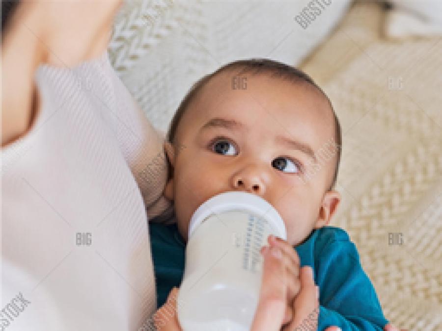 baby being fed a bottle of milk
